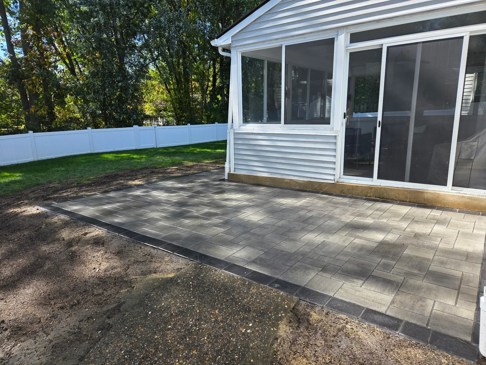 Paver Patio Screen Room Finished by Down To Earth Landscaping.